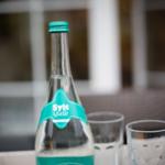 Eine Flasche Sylt Quelle Mineralwasser mit zwei Gläsern auf einem Tisch.