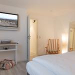 Schlafzimmer mit Bett, Fernseher und Stuhl.