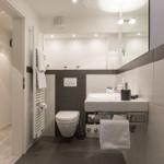 Badezimmer mit Waschbecken, Toilette und Heizung.