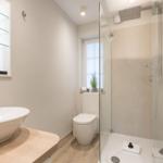Badezimmer mit Dusche, Waschbecken und Toilette.