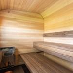 Sauna mit Holzbank und Ofen an der Wand.