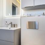 Modern bathroom with sink, mirror, and storage.