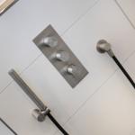 Showerhead with three controls on white wall