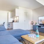 Living area with sofa, TV, and kitchen area