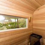 Sauna mit Holzwand und Fensterblick auf Garten