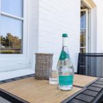 Auf der Terrasse steht ein Tisch mit Wasserflasche und Glas.
