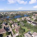 View of coastal town with lake, houses, and beach.