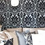 Sofa mit Kissen vor gemusterter Wand