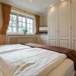 Bedroom with bed, window, and wardrobe.