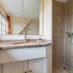 Bathroom with shower, sink, and mirror