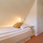 Bedroom with double bed, nightstand, and wardrobe.