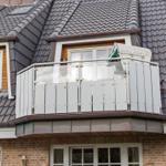 House with balcony, white railing, and wicker basket