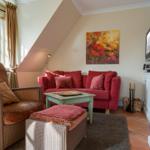 Living room with red sofa, fireplace, and wall art