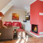 Living room with fireplace, sofa and armchair under sloped ceiling