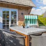 Terrace with dining table, chairs, and green-white awning.