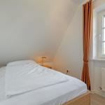 Bedroom with double bed, window, and radiator.