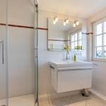 Bathroom with shower, sink, and window