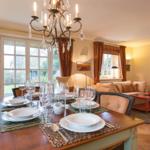 Dining table for six, living area with sofa and chandelier.
