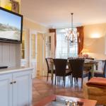 Living and dining area with TV, table, chairs, and windows.