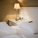 Bedroom with bed, nightstand, and lamp.