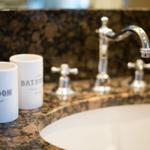 Bathroom with marble countertop and chrome faucets.