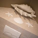 Bathroom area with white shells and starfish on tiles