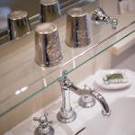 Bathroom with mirror, glass shelf, and chrome faucet