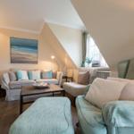Living room with sofa, armchair, and TV mounted on the wall