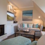Living room with fireplace, sofa, and TV mounted on the wall.