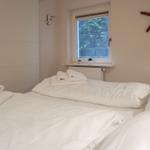 Schlafzimmer mit Bett, Fenster und Wanddekoration