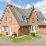 Red brick house with gray roof and white windows.