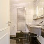 Bathroom with sink, mirror, and heater on wall