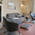 Living room with gray sofa, two armchairs, and a glass display cabinet.