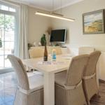 Dining room with table, chairs, and TV. Glass door leads to terrace.