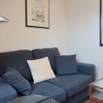 Ein grauer Sofa mit Kissen und einer Stehlampe in einem Wohnzimmer.