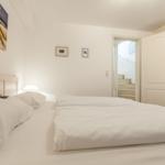 Bedroom with bed, wall art, and door to staircase