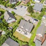 Aerial view of a residential area with multiple houses and well-kept gardens.