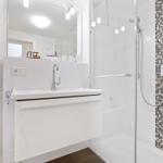 Bad mit Dusche, Waschbecken und Handtuchheizkörper