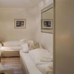 Zwei Betten mit weißen Bettwäsche, Wandbild und Spiegel an der Wand.