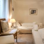 Zimmer mit zwei Betten, Fenster, Lampe und Wandbild.