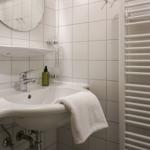 Badezimmer mit Waschbecken, Spiegel und Heizkörper