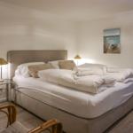 Ein Schlafzimmer mit großem Bett, zwei Nachttischen und Wandbildern an den Wänden.