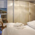 Schlafzimmer mit Bett, Kleiderschrank und Fernseher