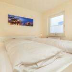 Schlafzimmer mit Doppelbett, Wandbild und Fenster