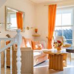 Wohnzimmer mit Sofa, Tisch und Blick auf Balkon.