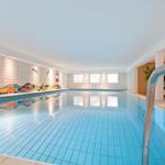 Innenpool mit blauen Fliesen und farbiger Wanddekoration