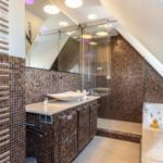 Dusche mit Glaswand, Badewanne und Waschbecken mit Mosaikwand