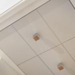 Weißer Schrank mit quadratischen Griffen und glatten Türen