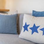 Sofa mit Kissen, eines mit drei blauen Sternen.