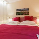 Bedroom with bed, nightstands, and wall art.
